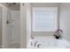 Bright bathroom includes a soaking tub, tiled shower, and window for natural light at 1141 Brookhill Way, Cary, NC 27519