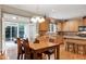 Inviting kitchen with warm wood cabinetry, granite countertops, and an adjacent dining area that exits to a covered patio at 1141 Brookhill Way, Cary, NC 27519