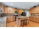 Bright kitchen featuring granite countertops, central island, wood cabinetry, and black appliances at 1141 Brookhill Way, Cary, NC 27519