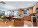 Open concept kitchen with island, wooden cabinets, and dining area that leads to sunroom at 1141 Brookhill Way, Cary, NC 27519