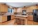 Charming kitchen with wood cabinets, granite countertops, island with seating, and modern appliances at 1141 Brookhill Way, Cary, NC 27519