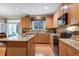 Spacious kitchen featuring an island with granite countertop, wooden cabinets, and modern appliances at 1141 Brookhill Way, Cary, NC 27519