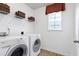 Well-lit laundry room with front load washer and dryer and shelving for storage at 1141 Brookhill Way, Cary, NC 27519