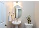 Elegant powder room featuring a pedestal sink, decorative mirror, and modern fixtures at 1141 Brookhill Way, Cary, NC 27519