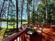 A scenic lake view from a wooden deck, furnished with a table and chairs for relaxation at 11813 Edgewater Ct, Raleigh, NC 27614