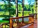 Inviting lake view from a wood deck featuring wooden rails and stairs surrounded by mature trees at 11813 Edgewater Ct, Raleigh, NC 27614