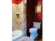 This bathroom features a tiled shower with a glass door and a classic white toilet under framed artwork at 11813 Edgewater Ct, Raleigh, NC 27614