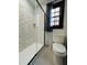 Bathroom featuring a glass shower, a tiled wall, a window, and a toilet at 11813 Edgewater Ct, Raleigh, NC 27614