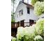 View of home with dark windows, white siding, and a wooden porch, accented by lush white hydrangea blossoms at 11813 Edgewater Ct, Raleigh, NC 27614