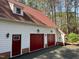Exterior view of garage featuring red doors, dormer window, and brick foundation at 11813 Edgewater Ct, Raleigh, NC 27614