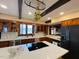 Bright kitchen featuring wood cabinets, white countertops, black appliances, and a view to the outside at 11813 Edgewater Ct, Raleigh, NC 27614