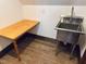 Functional laundry area with stainless steel sink, wood table, and stylish tile flooring at 11813 Edgewater Ct, Raleigh, NC 27614