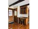 Office nook featuring wood floors, a built-in desk, and a glass cabinet at 11813 Edgewater Ct, Raleigh, NC 27614
