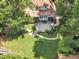 Aerial view of landscaped backyard with patio, outdoor fireplace, and mature trees surrounding a well-maintained lawn at 1225 Fanning Dr, Wake Forest, NC 27587