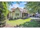 A lovely backyard showcasing the home's exterior, screened porch, lush landscaping, and a convenient stone pathway at 1225 Fanning Dr, Wake Forest, NC 27587
