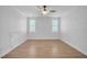 Sunny bedroom with hardwood floors, white walls, and two windows at 1225 Fanning Dr, Wake Forest, NC 27587