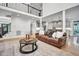 Open-concept living room with a large leather sofa, cathedral ceiling, and view of the modern kitchen at 1225 Fanning Dr, Wake Forest, NC 27587