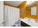 Full bathroom with vanity, toilet, tub and shower is painted a vibrant orange color at 1303 Bent Willow Dr, Durham, NC 27704