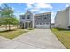 Two-story home with gray siding, well-kept lawn, and a concrete driveway leading to a garage at 1303 Bent Willow Dr, Durham, NC 27704