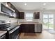 Bright kitchen features stainless steel appliances, dark cabinets, and a sliding glass door at 1303 Bent Willow Dr, Durham, NC 27704