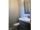 Cozy half bathroom with modern sink, wood-style vanity, and tiled flooring at 157 Thorpe St, Henderson, NC 27536