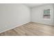 Clean, empty bedroom features light wood floors, neutral walls, and a window with blinds at 1730 Pie Filling Dr, Haw River, NC 27258