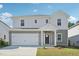 An exterior shot showcases a charming two-story home with attached two car garage and manicured front lawn at 1730 Pie Filling Dr, Haw River, NC 27258
