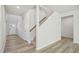 Bright foyer featuring wood-look flooring, neutral walls, a staircase, and natural light from the front door at 1730 Pie Filling Dr, Haw River, NC 27258