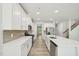 Bright kitchen showcasing white cabinets, stainless steel appliances, a tiled backsplash, and hardwood floors at 1730 Pie Filling Dr, Haw River, NC 27258