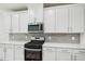 Stylish kitchen featuring white cabinetry, stainless steel appliances, light countertops, and a tiled backsplash at 1730 Pie Filling Dr, Haw River, NC 27258