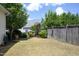 A spacious, grassy backyard enclosed by a wooden fence and mature trees at 1940 Dunfield Dr, Fuquay Varina, NC 27526