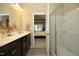 Bathroom featuring a double vanity with dark cabinets and a glass door shower at 1940 Dunfield Dr, Fuquay Varina, NC 27526
