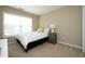 This well-lit bedroom features a bed, a nightstand, and a large window at 1940 Dunfield Dr, Fuquay Varina, NC 27526