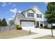 View of the home's exterior showcasing the yard, 2 car garage and well-maintained landscaping at 1940 Dunfield Dr, Fuquay Varina, NC 27526
