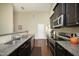 Spacious kitchen with stainless steel appliances, granite countertops, dark cabinets and hardwood floors at 1940 Dunfield Dr, Fuquay Varina, NC 27526