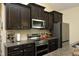 Well-lit kitchen with stainless steel appliances, granite countertops, and dark cabinets at 1940 Dunfield Dr, Fuquay Varina, NC 27526