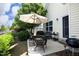 Outdoor patio area with chairs, an umbrella, grill, and lush landscaping at 1940 Dunfield Dr, Fuquay Varina, NC 27526