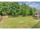 This home features a large green backyard with a wood fence and mature trees around the perimeter at 196 Norwich Dr, Clayton, NC 27520