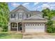 Charming two-story home with stone accents, shingle siding, attached two-car garage, and beautifully maintained landscaping at 196 Norwich Dr, Clayton, NC 27520
