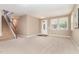 Bright living room featuring neutral carpet, staircase and natural light from the large window at 196 Norwich Dr, Clayton, NC 27520