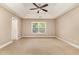 An empty primary bedroom features a tray ceiling, neutral paint, and a window with natural light at 196 Norwich Dr, Clayton, NC 27520
