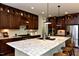 A kitchen featuring wood cabinets, granite countertops, stainless steel appliances, and a large kitchen island at 211 George Hudson Rd, Siler City, NC 27344