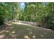 Backyard features a large grassy area and a wooden fence surrounded by tall, shady trees at 215 Rocky Point Ct, Fuquay Varina, NC 27526