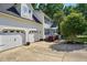 Side view of a two-story home with a three car garage and green lawn at 215 Rocky Point Ct, Fuquay Varina, NC 27526