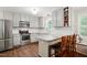 Updated kitchen features grey cabinets, stainless appliances, granite counters, and breakfast bar at 215 Rocky Point Ct, Fuquay Varina, NC 27526