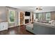 Inviting living room with hardwood floors, fireplace, built-in bookshelves, and large windows at 215 Rocky Point Ct, Fuquay Varina, NC 27526