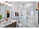Bright bathroom features a glass enclosed shower, white cabinets, a quartz countertop and upgraded gold fixtures at 217 George Hudson Rd, Siler City, NC 27344