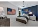This bedroom features a blue accent wall, unique light fixture, and sports themed décor, and an American flag at 217 George Hudson Rd, Siler City, NC 27344