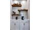 Butler's pantry with marble tile backsplash, floating shelves, and quartz countertop at 217 George Hudson Rd, Siler City, NC 27344