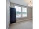 Well-lit bedroom with neutral walls, carpet flooring, an open door, and two windows with views at 219 George Hudson Rd, Siler City, NC 27344
